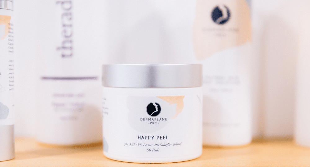 DermaplanePro products with a focus on a jar of Happy Peel for a blog article on how to add a peel to a dermaplaning treatment.