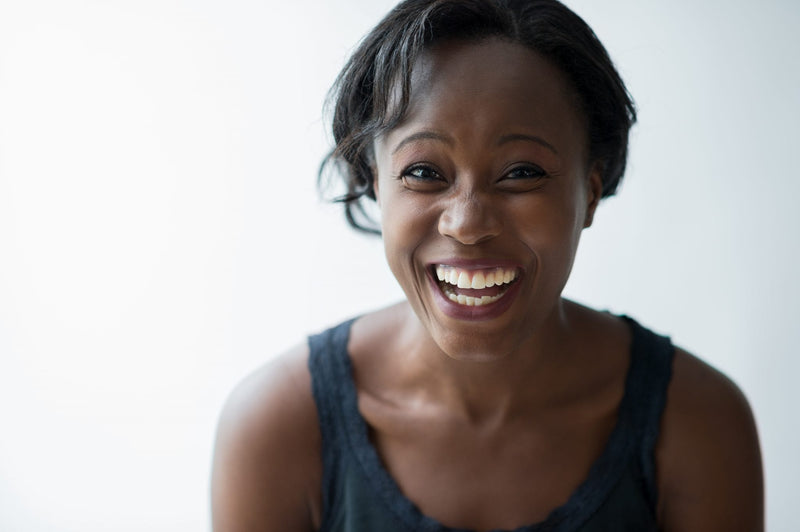 Woman in tank top smiling toward the camera.