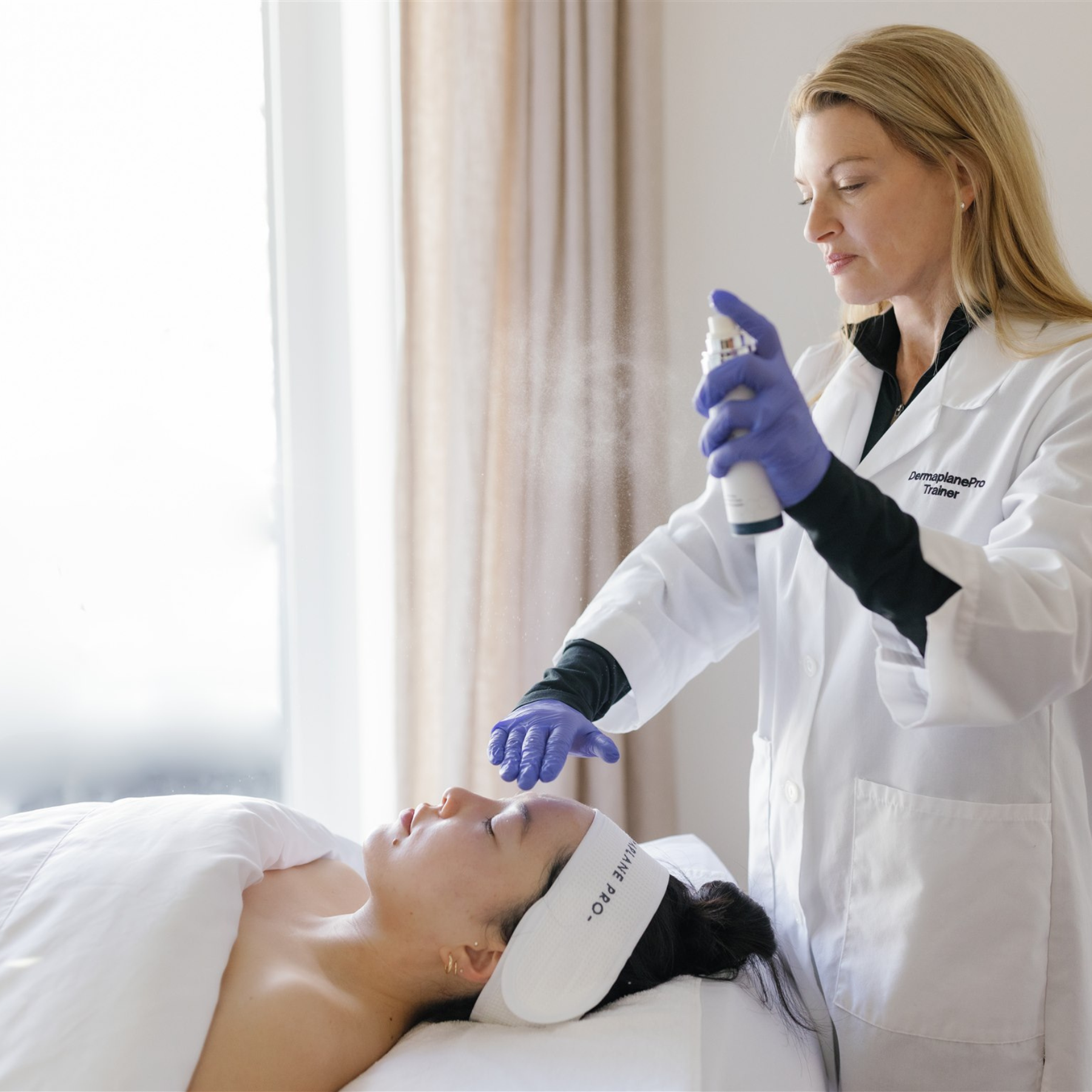 Esthetician spraying Satisfaction Mist on a client. Used as a hydrating and setting mist.
