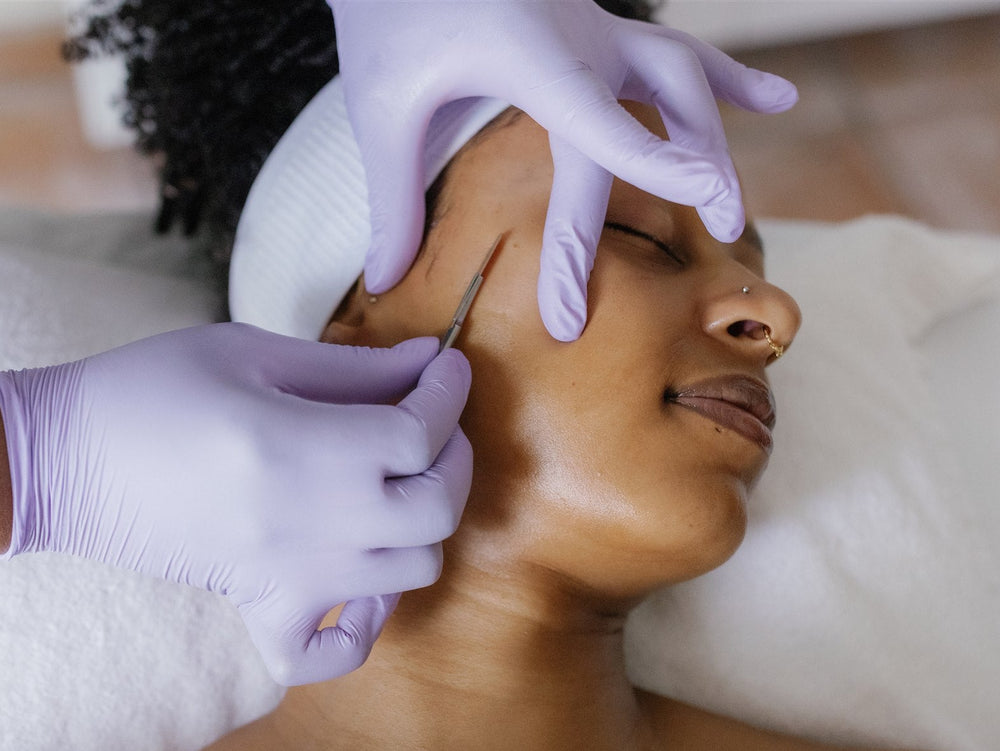 Person receiving a facial treatment with gloves on hands