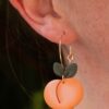 Handmade, peach-shaped, clay dangle earrings by Speckled Designs.
