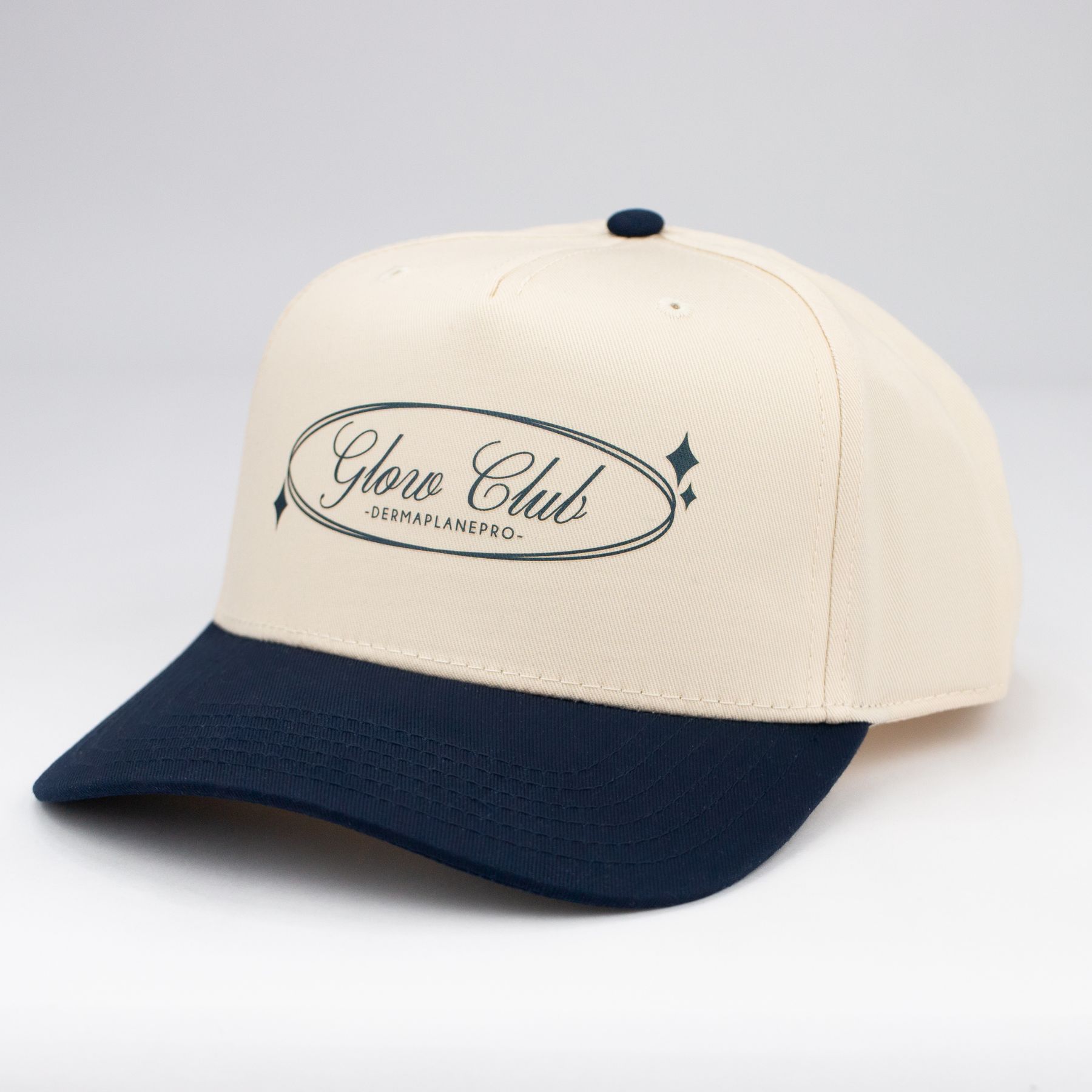 DermaplanePro Glow Club baseball hat with a natural fabric color cap and navy bill.
